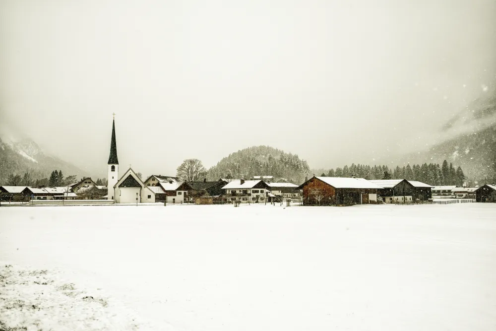 Verschneites Dorf bei Schneefall im Winter